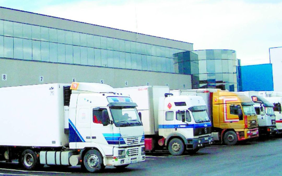 Camiones ante un almacén de mercancías.